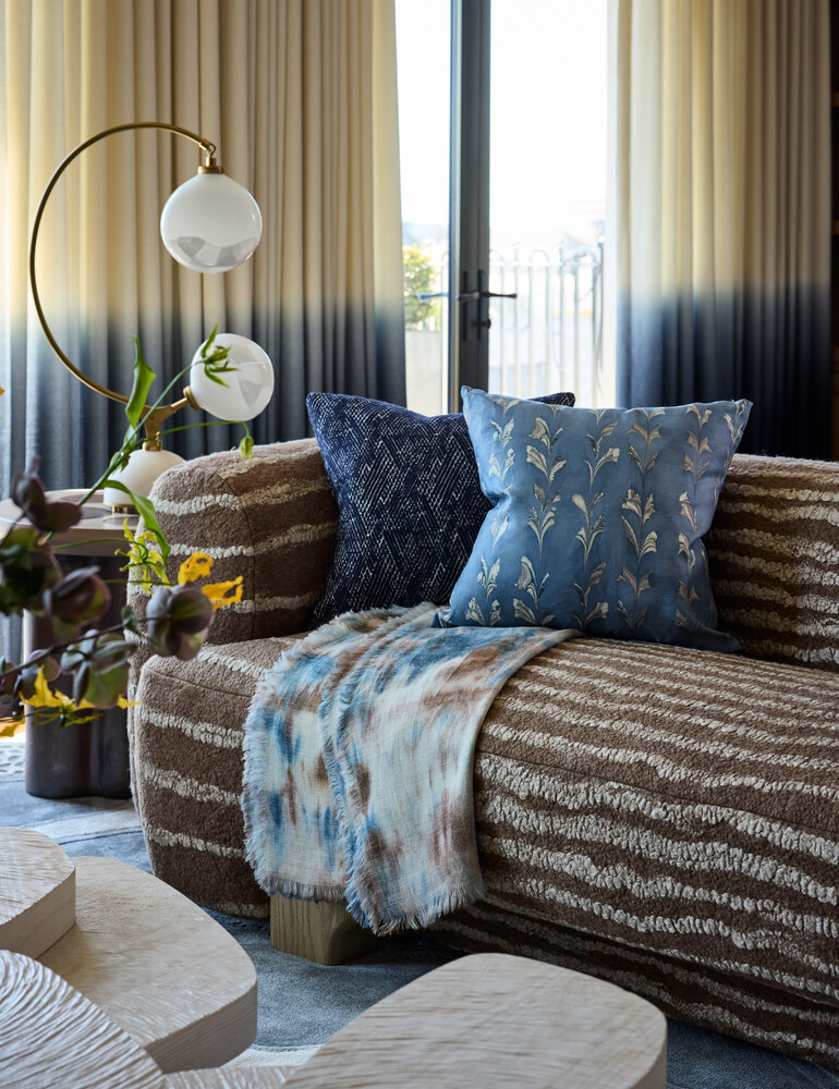 Interior detail of plush couch and throw pillows near large windows in Tiburon home by S.A. Baxter, Inc.