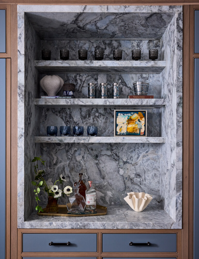 Marble niche bar with floating shelves and curated glassware in a Mill Valley custom home by S.A. Baxter, Inc.