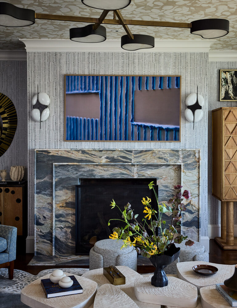 Stone fireplace with art display and modern light fixtures in Sausalito home by S.A. Baxter, Inc.