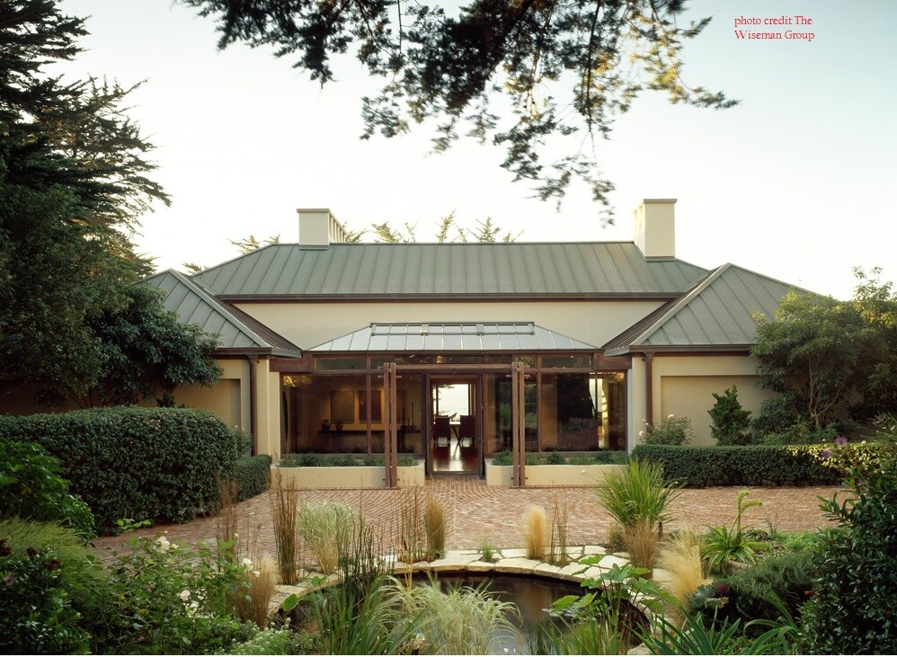 Classic front exterior with modern architectural elements and pond feature by S.A. Baxter, Inc. in Carmel Highlands.