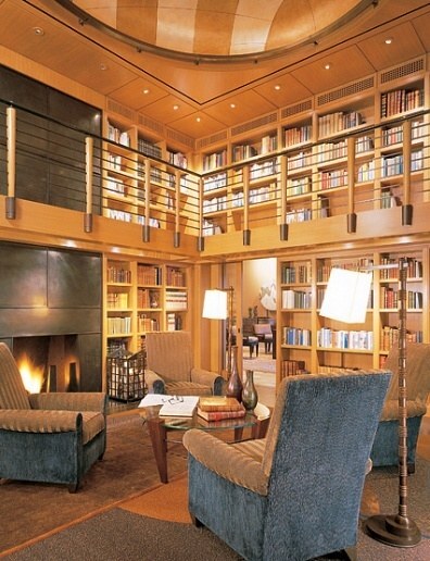 Grand home library featuring mezzanine, fireplace, and built-in bookcases in Carmel Highlands custom home by S.A. Baxter, Inc.