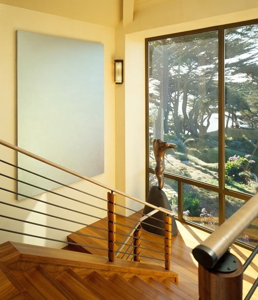 Stairwell with sculptural decor and large picture window overlooking nature by S.A. Baxter, Inc. in Carmel Highlands, CA.