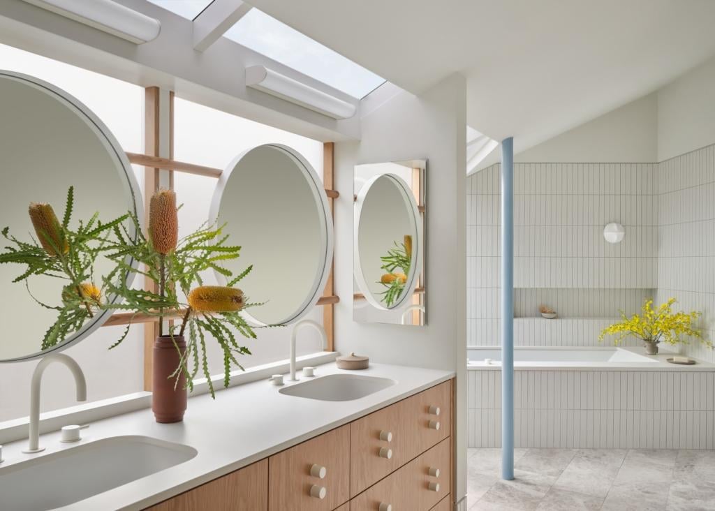 Double-sink vanity with round mirrors and natural light in a Marin County custom home by S.A. Baxter, Inc.