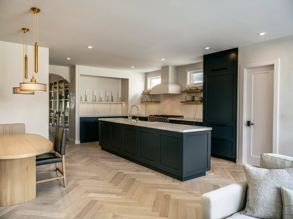 Custom kitchen with dark cabinets, marble backsplash, and herringbone floors by S.A. Baxter, Inc., Marina District