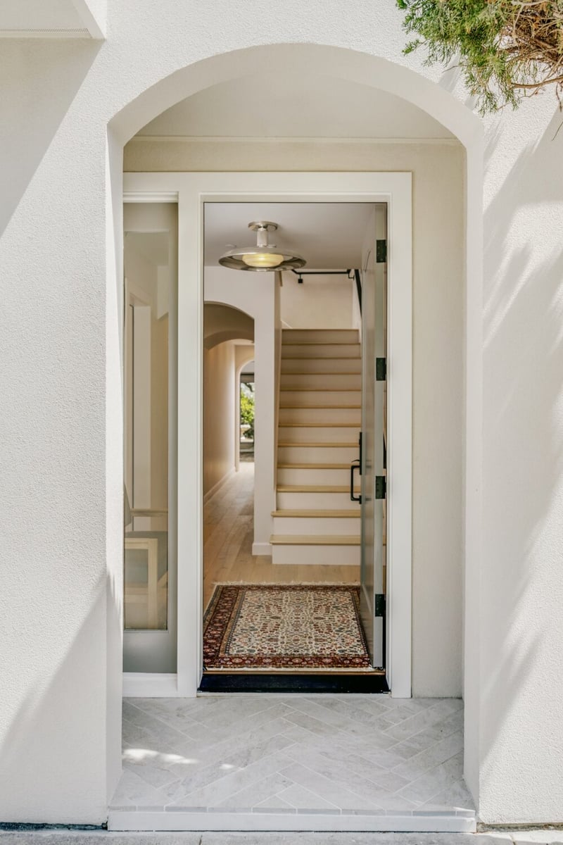 Front door entry with arched threshold and light-filled hallway by S.A. Baxter, Inc. in Marina District custom home