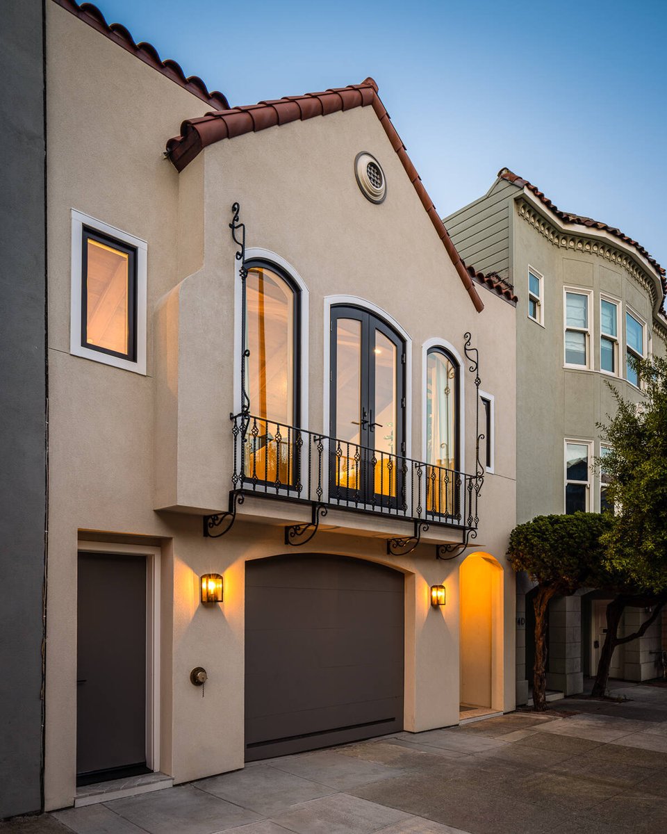 Front view of Marina District custom home with wrought iron balcony and evening lighting by S.A. Baxter, Inc.