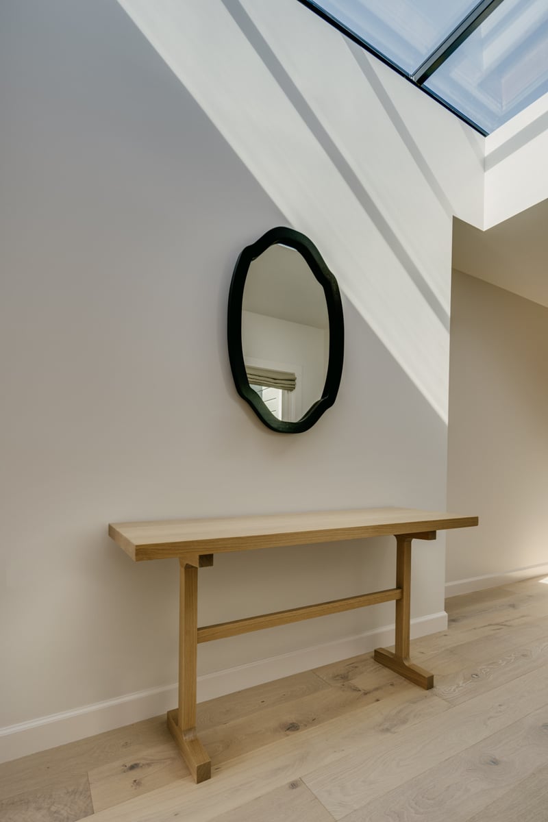 Skylit hallway with wood console and decorative mirror in Marina District custom home by S.A. Baxter, Inc.