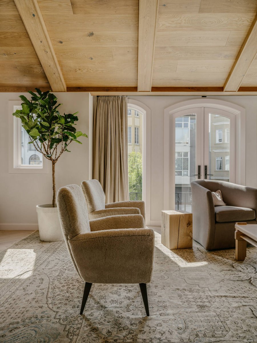 Sunlit seating area with natural wood ceiling and vintage-style rug by S.A. Baxter, Inc., Marina District, CA