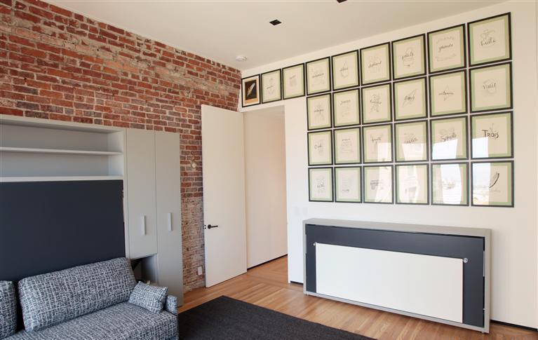Custom room featuring exposed brick wall and framed artwork in Nob Hill home by S.A. Baxter, Inc.