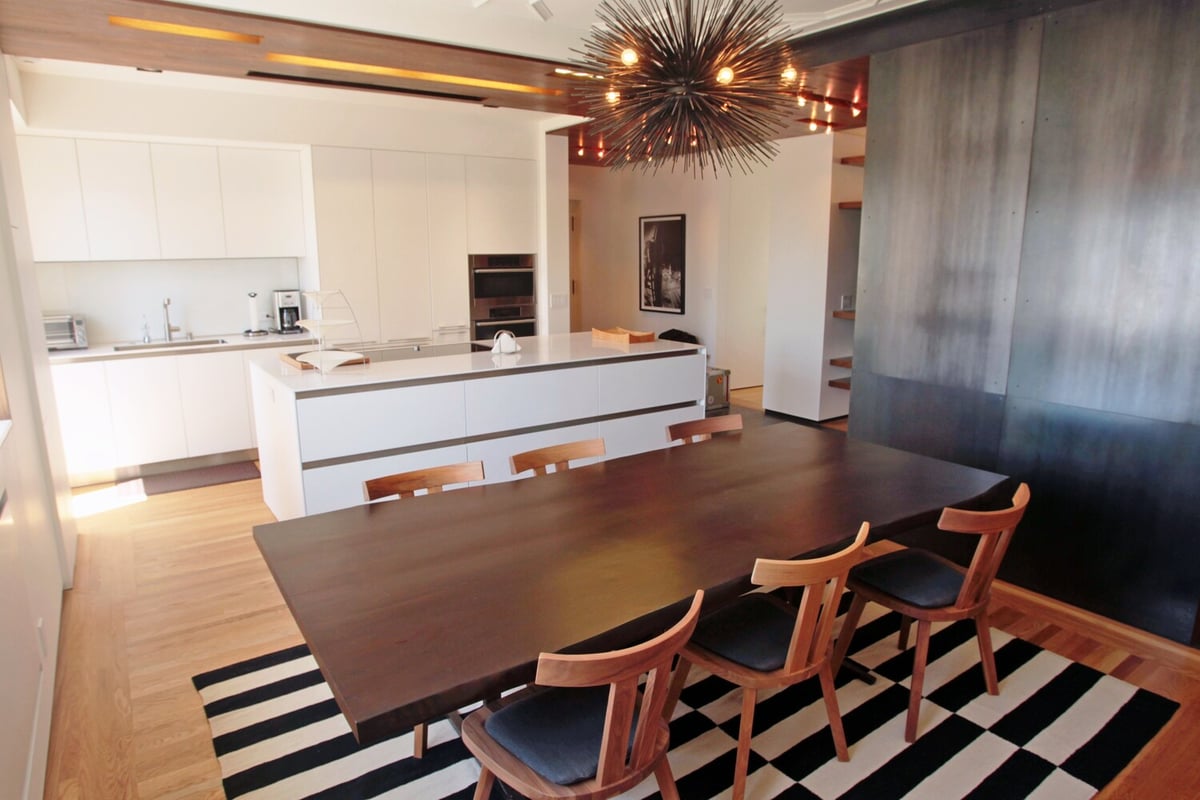 Modern kitchen and dining space with striking chandelier in custom Nob Hill, CA home by S.A. Baxter, Inc.