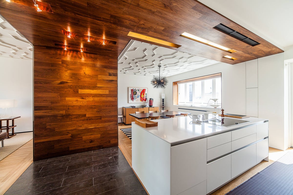 View of white kitchen island and dining area with wood and black finishes in Nob Hill custom home by S.A. Baxter, Inc.