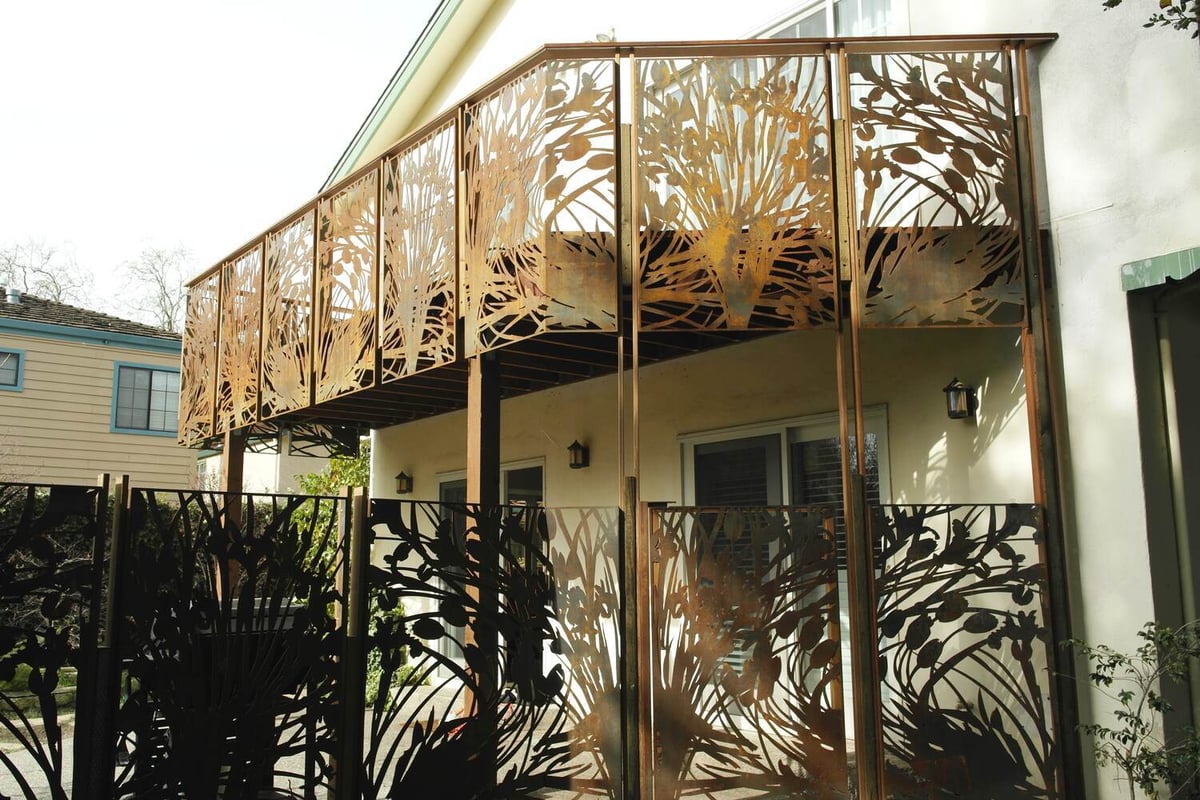 Side view of custom balcony and privacy screen with rusted floral cutouts by S.A. Baxter, Inc., Palo Alto.