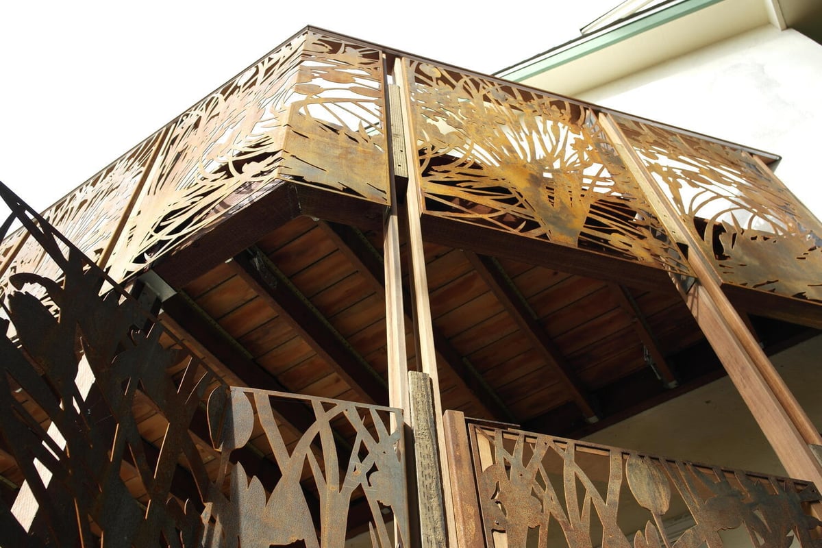 Upward view of custom corner balcony panels with intricate nature designs by S.A. Baxter, Inc., Palo Alto.