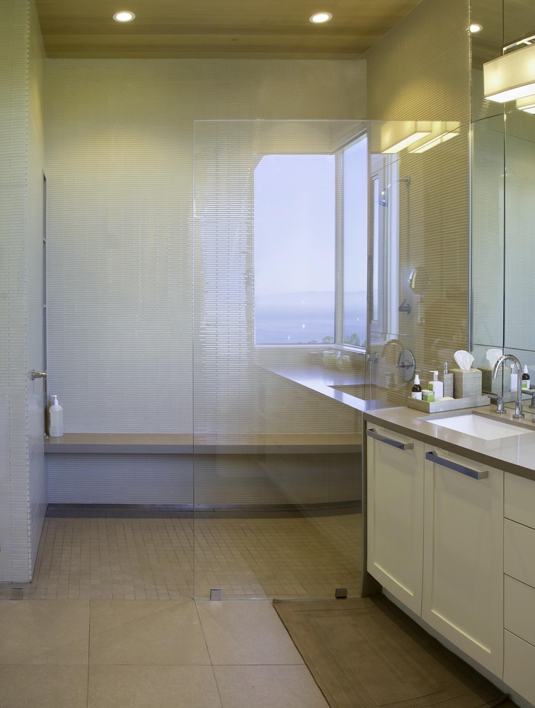 Luxurious walk-in shower with bench and floating vanity in Tiburon bathroom by S.A. Baxter, Inc.