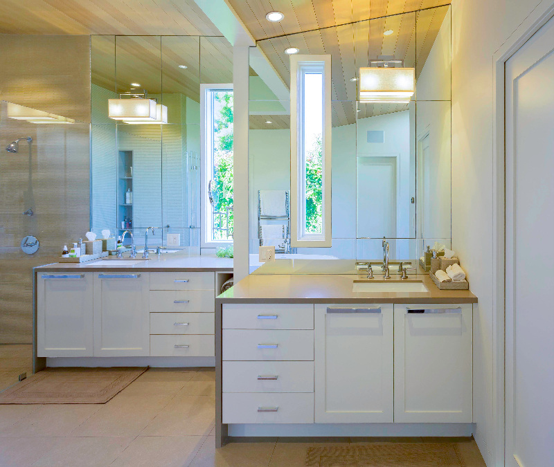 Modern white bathroom with dual vanities and tall window in Tiburon custom home by S.A. Baxter, Inc.