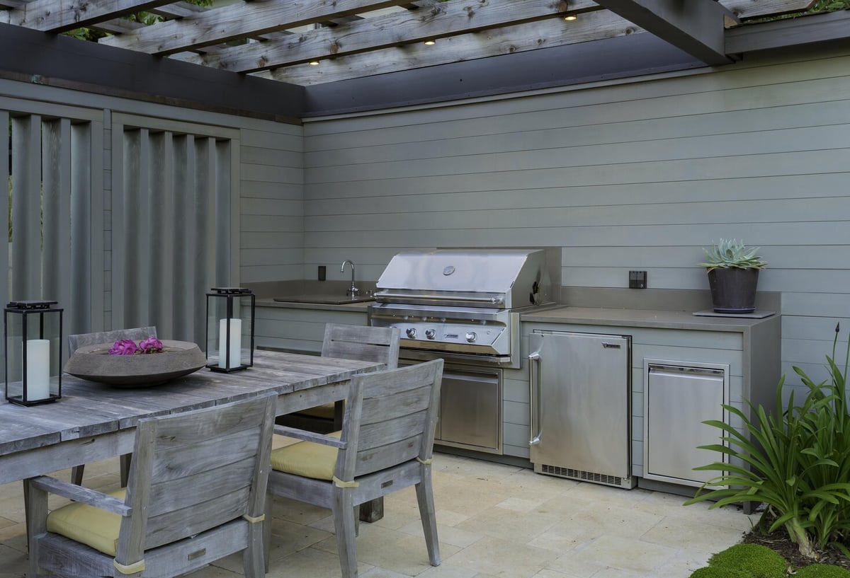 Outdoor kitchen with stainless grill and modern cabinetry in Tiburon home by S.A. Baxter, Inc.
