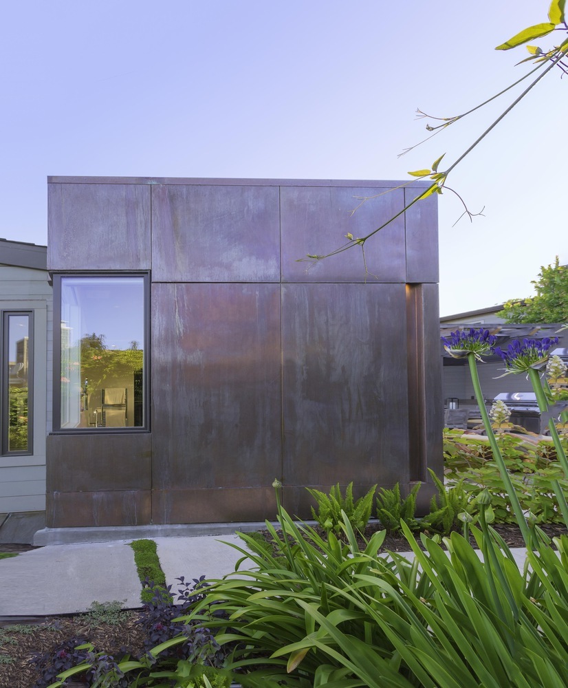 Side view of modern copper-clad addition with lush landscaping in Tiburon home by S.A. Baxter, Inc.