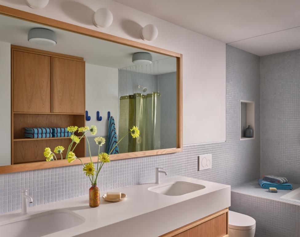 Dual-sink bathroom with large mirror and light blue tile in a custom home by S.A. Baxter, Inc. in Marin County, CA