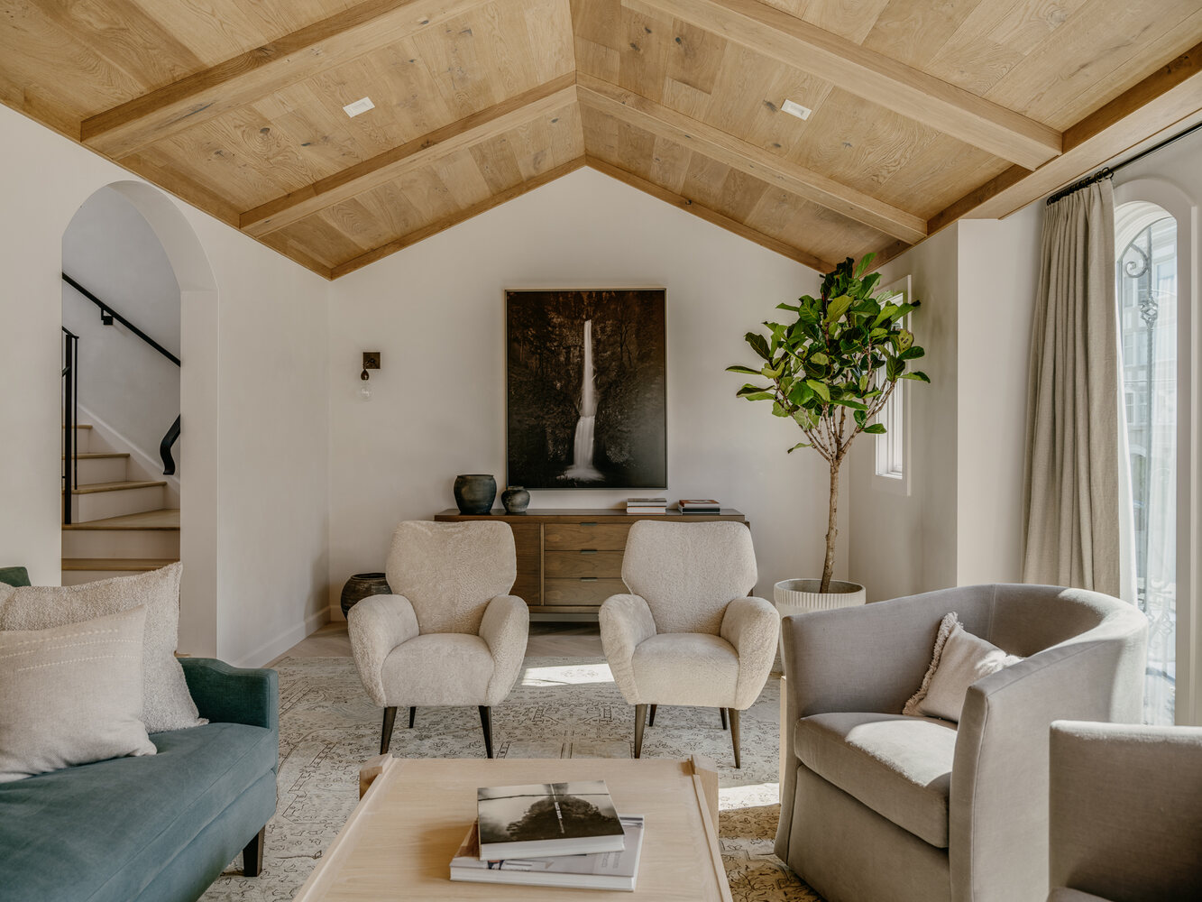 Vaulted ceiling living room with neutral furnishings and natural wood details in Belvedere by S.A. Baxter, Inc.